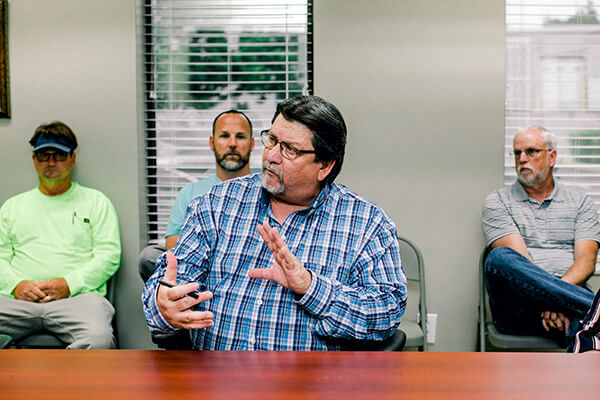 A professional discusses details from a feasibility study with the land planning and surveying team. 