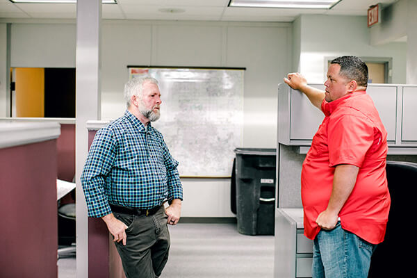 Two surveying professionals discussing a project. 