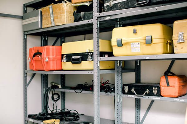 A shelf lined with land surveying equipment. 