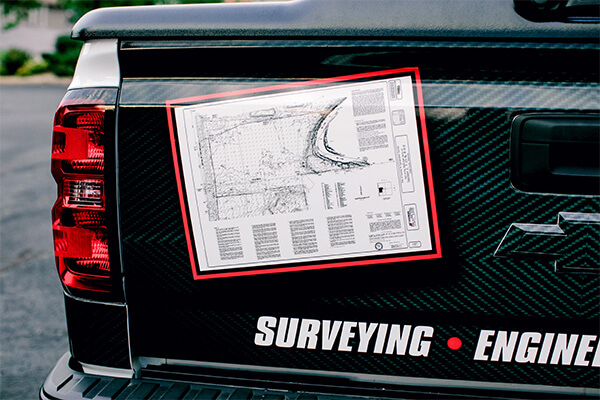 A decal of a surveying map on the back of a black truck. 