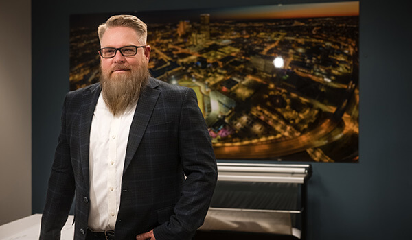 Shawn Collins standing in a conference room wearing a suit. 