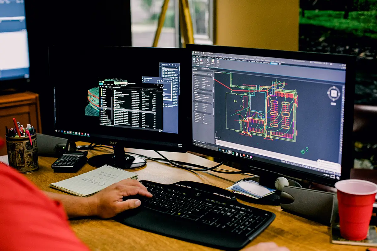 What Is Land Surveying Used For? | Sisemore & Associates Land surveyor Tulsa reviewing CAD site plans and boundary data on dual monitors in an office setting