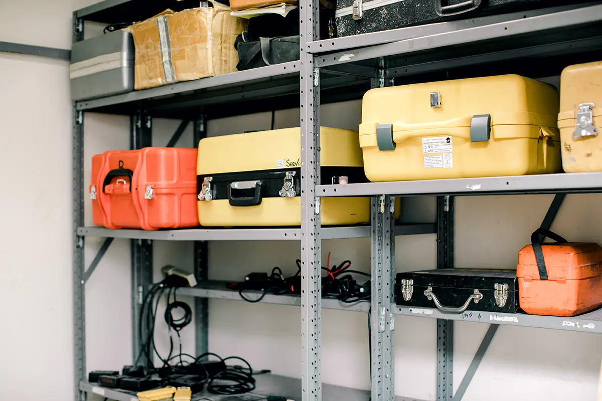 Survey equipment storage cases on metal shelving