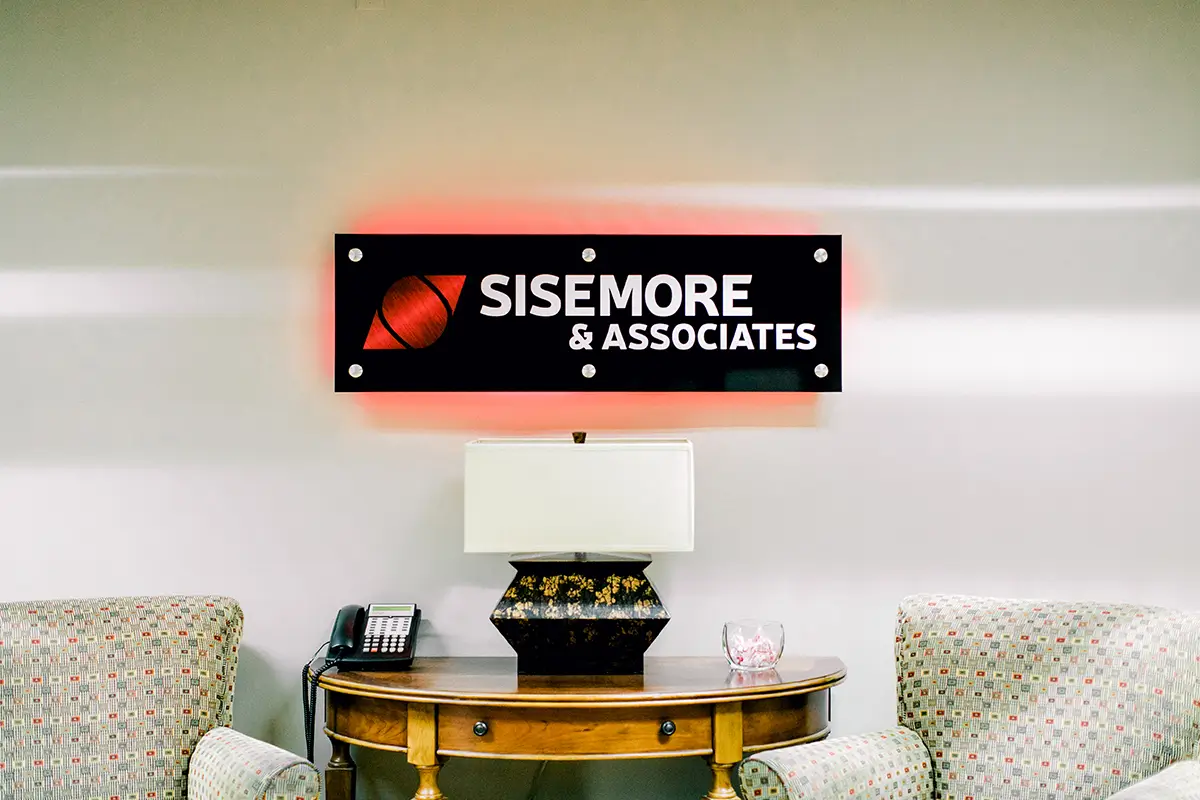 isemore & Associates office reception area with the company sign displayed above a desk and chairs.